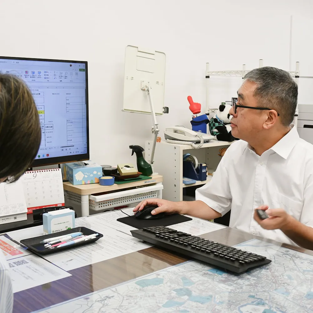 事務所で接客をしているロータス不動産代表春日の画像